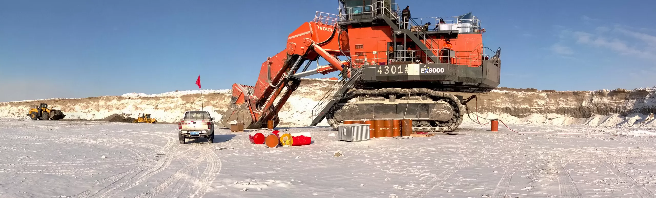 Panoramic photo of an icy landscape where a gigantic excavator is  parked at a mining operation in Inner Mongolia