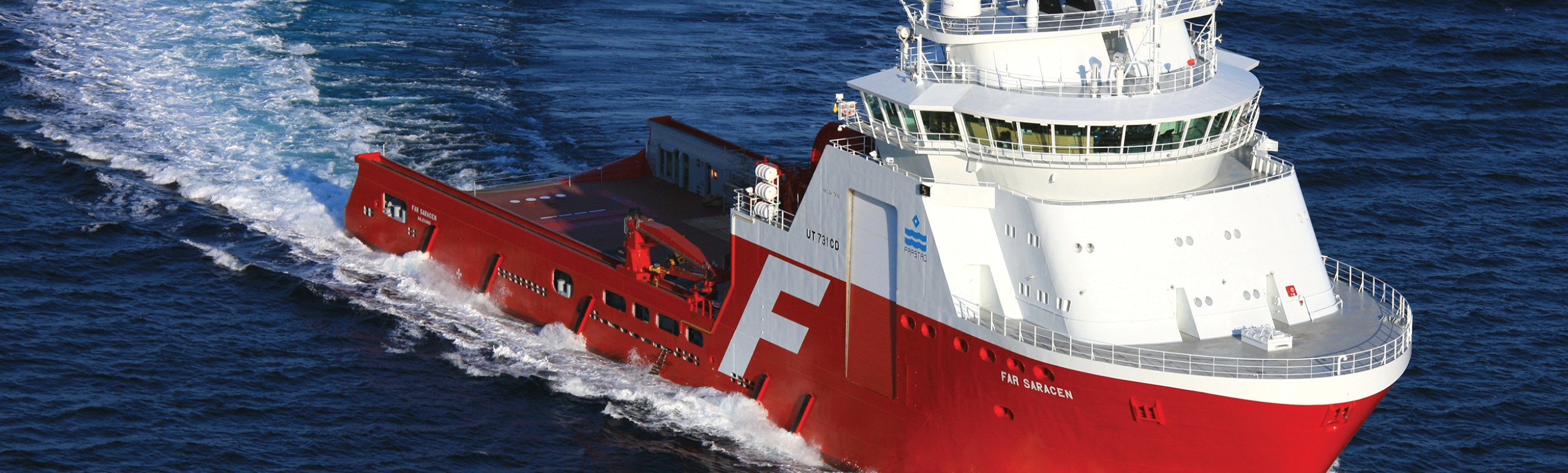 An offshore supply ship called the Far Saracen is turning through a body  of water causing a wave of water in its wake 