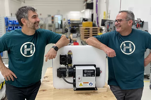 Two Hotstart employees stand next to an engine heater they assembled and are preparing for shipment.